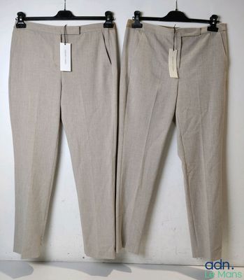 a pair of pants hanging on a hanger in front of a white wall
