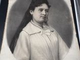 an old picture of a woman with long hair in a white dress