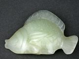 une image représentant un poisson sculpté sur une surface noire