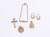 a gold necklace, earrings, and a cross on a white background
