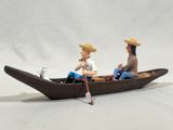 two figurines of two people in a boat on a white background