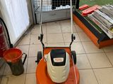 a lawn mower that is sitting on the floor in a room