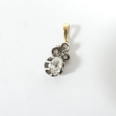 une photo d'un pendentif en diamant posé sur une surface blanche