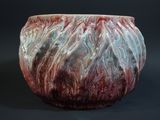 a close up of a red and white vase on a black background
