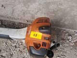 a chainsaw that is laying on the ground next to a cat
