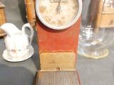a clock that is sitting on a table next to a vase