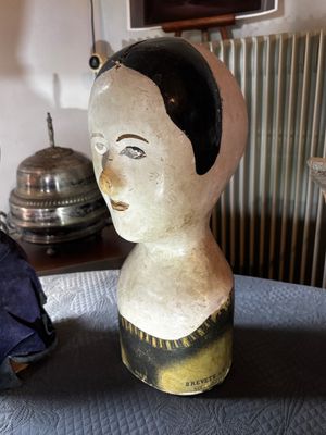 une statue représentant une femme assise sur un lit, à côté d'un parapluie