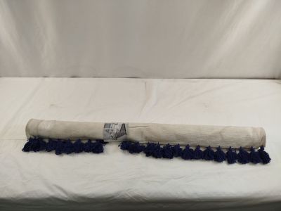 des pompons bleus et blancs sur un lit recouvert d'un drap blanc