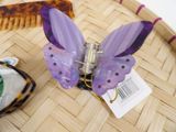 a purple butterfly hair comb sitting on top of a wooden tray