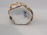 two porcelain figurines of a shell with a flower in the middle