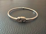 a silver bracelet with brown stones on a black leather surface