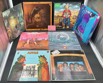 Diverses pochettes d'albums sont exposées sur une table dans une vitrine.
