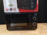 a black microwave sitting on top of a wooden table