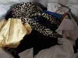 a pile of clothes in a basket on a bed