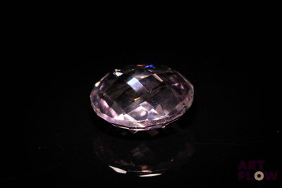 a close up of a pink diamond on a black surface