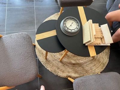 une personne assise à une table sur laquelle se trouve une horloge
