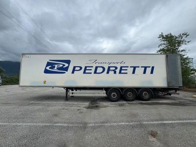 un semi-remorque blanc garé sur un parking, avec le ciel en arrière-plan