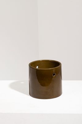 bougeoir en céramique marron posé sur une table blanche, sur fond blanc