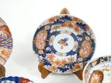 several plates and bowls are sitting on wooden stands on a white surface