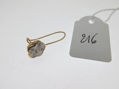un gros plan sur une paire de boucles d'oreilles avec une étiquette de prix posée sur une table