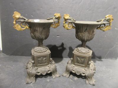 two silver vases sitting on top of each other