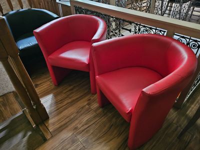 two red chairs sitting next to each other on a wooden floor
