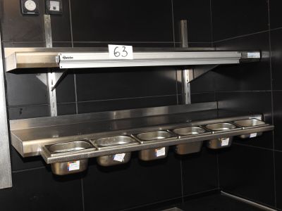 une rangée de lavabos dans des toilettes publiques, avec une affiche accrochée au mur