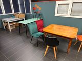 brightly colored chairs and a table in a room with blue walls