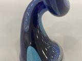 a close up of a blue and black vase with a silver base