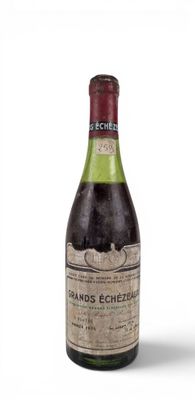 an old bottle of wine sitting on top of a white surface