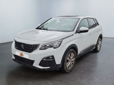 La voiture blanche est garée dans une grande pièce au sol noir.