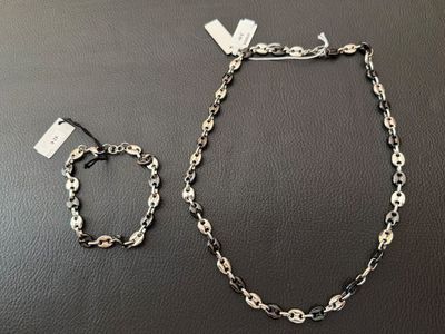 two pieces of jewelry are sitting on a black surface