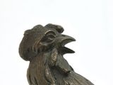 a statue of a rooster sitting on top of a table