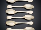 six silver spoons and two silver spoons on a black surface