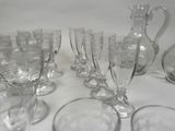 a lot of glasses and a pitcher sitting on a table