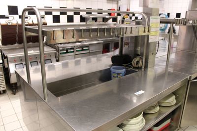 plan de travail en acier inoxydable dans une cuisine professionnelle, sur lequel sont posés des plats