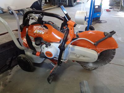 a small orange and white motorcycle parked in a garage