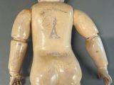a wooden doll that has a tattoo on it ' s back