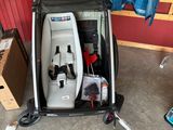a baby stroller in a garage with a blue shirt hanging on the wall