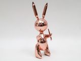 a metal rabbit figurine with a bow and arrow in its hand