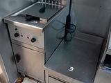 une cuisinière et un four dans une cuisine au sol carrelé