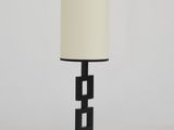 une lampe de table noire surmontée d'un abat-jour blanc