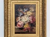 painting of a vase of flowers in a gold frame on a white wall