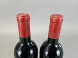 two bottles of wine sitting next to each other on a table