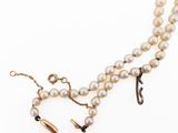 a close up of a necklace with pearls on a white background