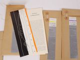 three brown envelopes with papers attached to them on a table