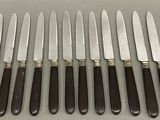 six knives are lined up next to each other on a table