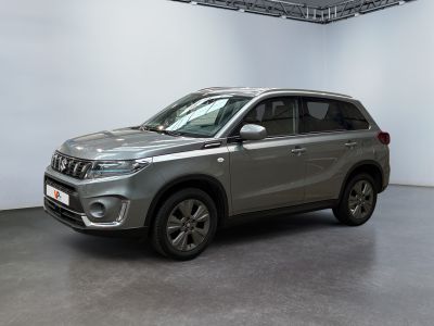 Le SUV argenté est garé dans une grande pièce aux murs blancs.