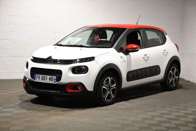 la petite voiture blanche est garée dans une pièce au sol à carreaux