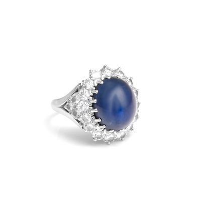 un gros plan sur une bague sertie d'un saphir étoilé bleu et de diamants